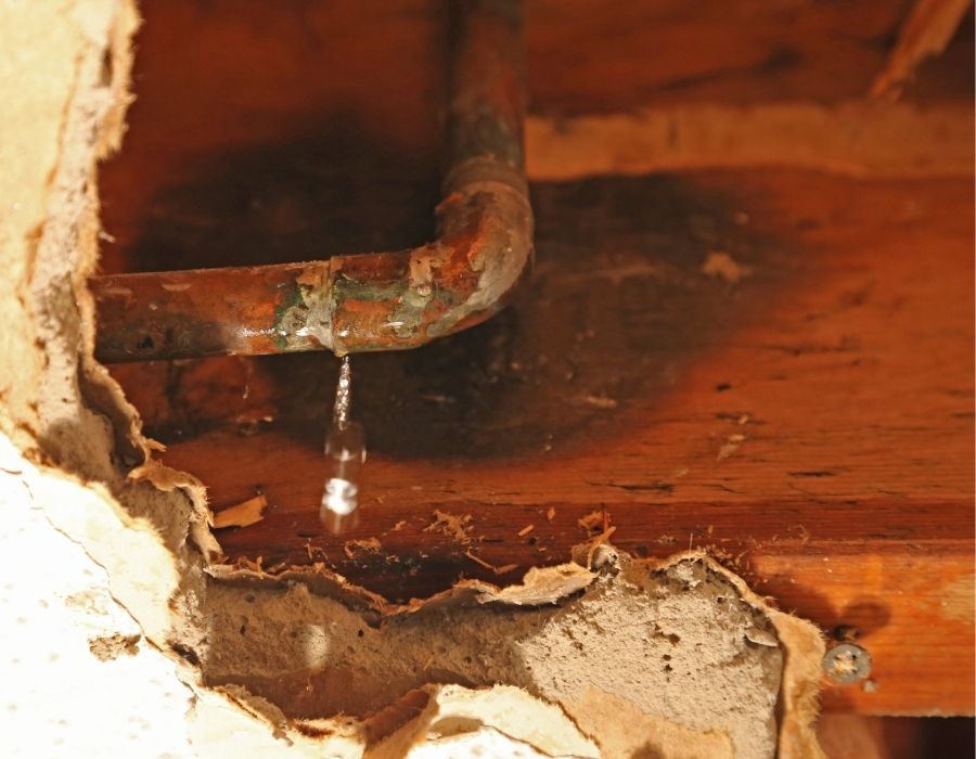 leaking-drain-pipe Leaking copper pipe behind drywall causing water damage and requiring plumbing leak repair