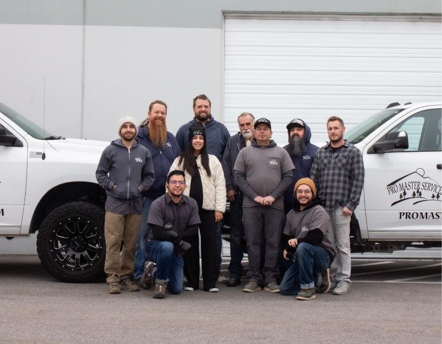 pro-master-services-team Pro Master Services plumbing team standing in front of service trucks outside their office, ready to provide residential and commercial plumbing services