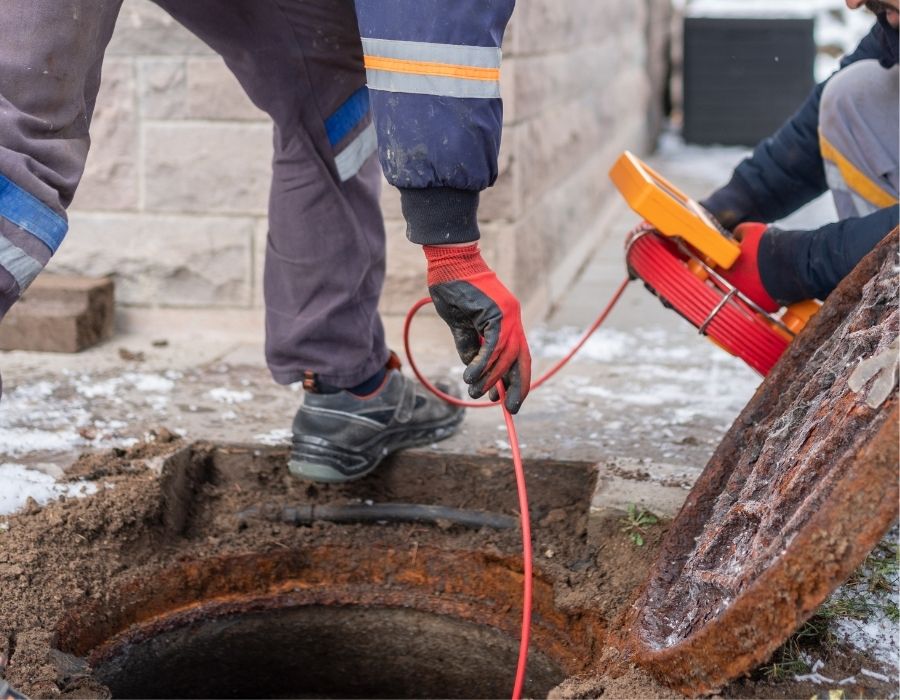 sewer-inspections-with-camera Plumbers using a sewer camera inspection tool to locate and diagnose underground sewer line issues during residential plumbing service