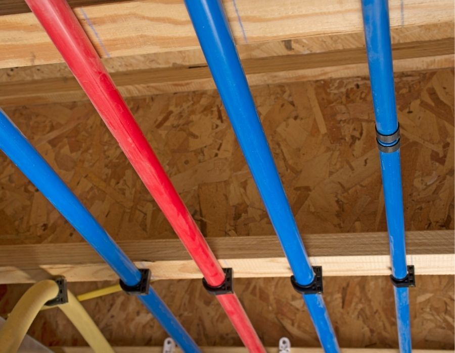 pex-pipe Red and blue PEX pipes installed for residential plumbing system during new construction