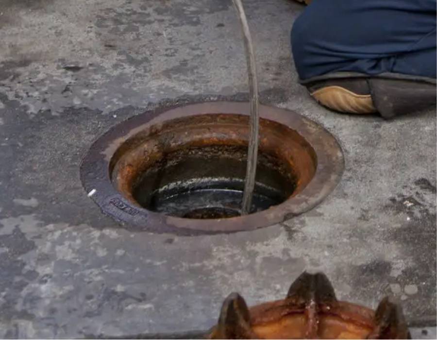 Hydro jetting service clearing a commercial drain with high-pressure water stream