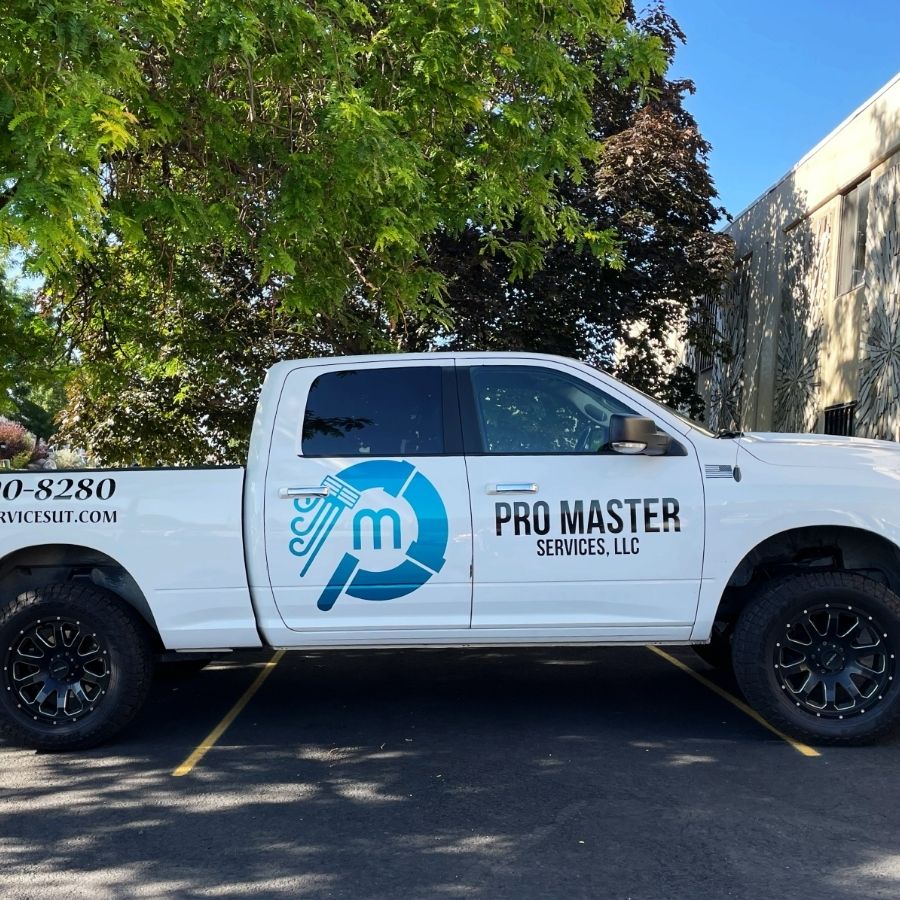 White Pro Master Services LLC work truck with company logo, phone number, and website parked under a tree in a sunny parking lot in Utah