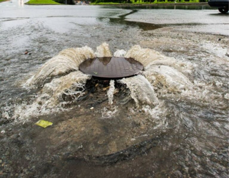 "Sewage overflow flooding from a manhole cover after heavy rain – emergency drain and sewer backup services in Utah