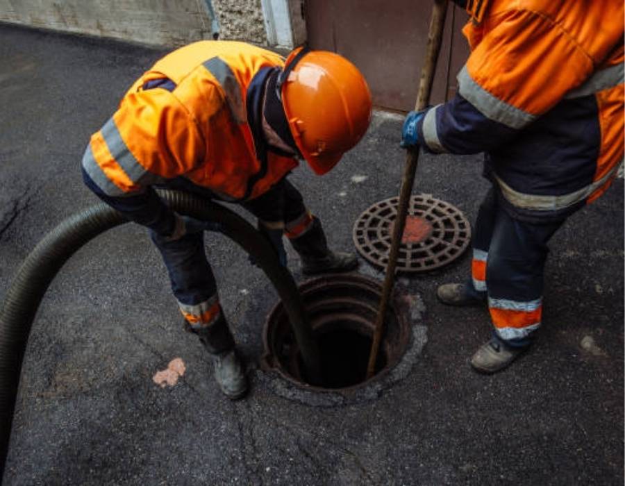 Pro Master Services plumbers handling commercial plumbing emergency with sewer line cleaning equipment