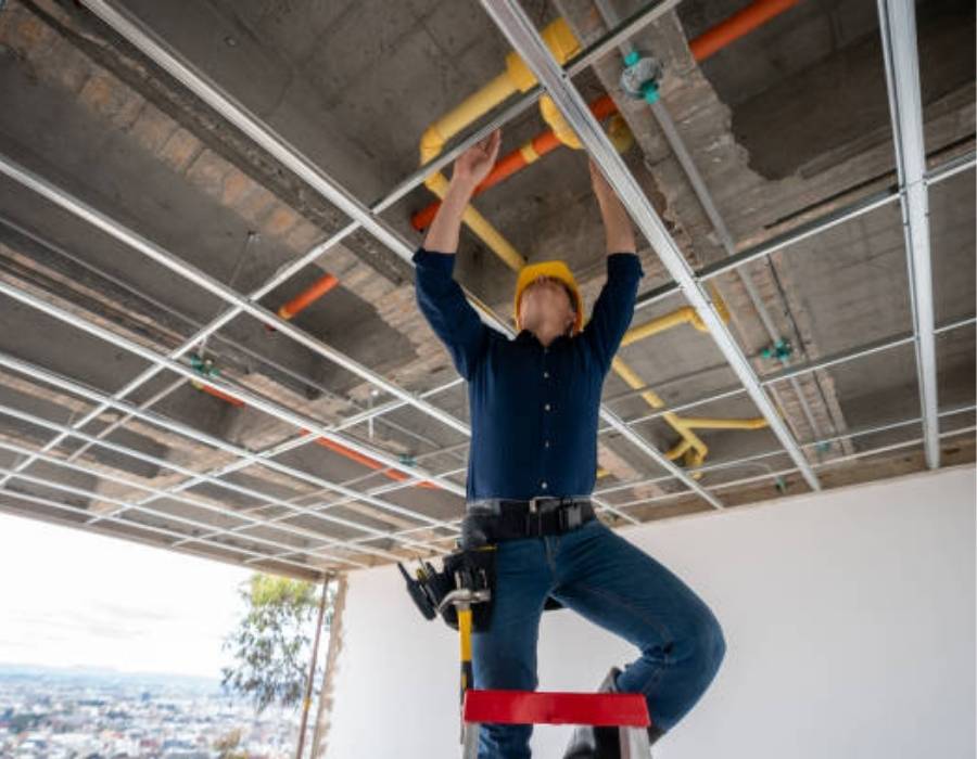Commercial plumber in Salt Lake City installing overhead pipes during building construction project